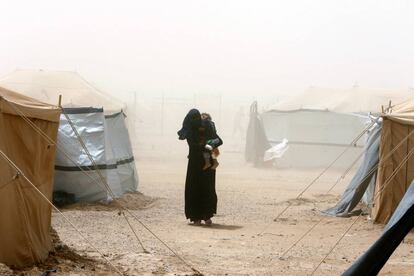 Una mujer lleva a su hijo durante una tormenta de arena en el campamento de refugiados en Ameriyat Faluya, Irak.