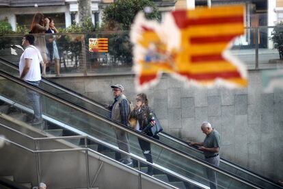 Una pegatina con la bandera nacional española y catalana aparece rota en un cristalera en la Gran Via de les Corts, en Barcelona.