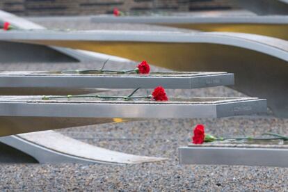Varias flores yacen en el suelo sobre el monumento por las víctimas erigido en el Pentágono.