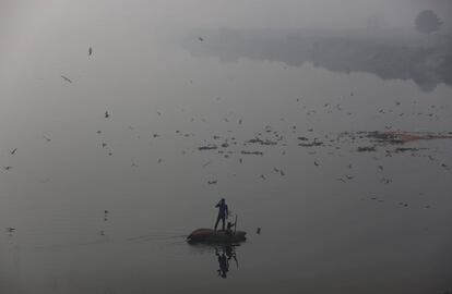 Dos jovenes buscan basura para reciclar en las aguas del río Yamuna, en Nueva Delhi (India).