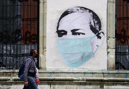 Una pareja camina este lunes junto a un mural alusivo al uso de las mascarillas, en una calle de Oaxaca (México). Las autoridades del sureño Estado de Oaxaca ordenaron en las últimas horas el confinamiento voluntario pero estricto en varias zonas de esta empobrecida región ante un considerable aumento de contagios.