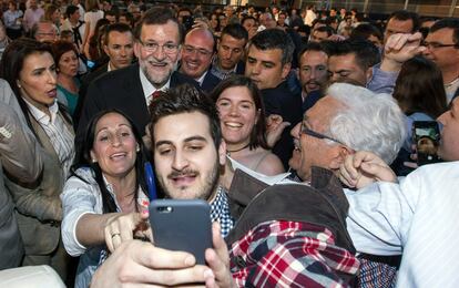 Rajoy participa en un mitin en Murcia junto al al candidato en esa comunidad, Pedro Antonio Sánchez, durante la campaña de las elecciones autonómicas y municipales del 24-M. Un simpatizante retrata el momento con el teléfono móvil.
