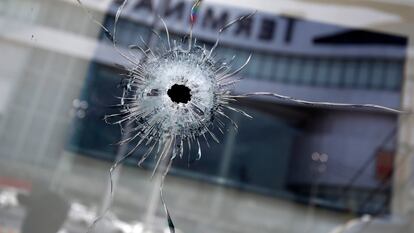 Buracos de bala são vistos ao lado do reflexo do prédio do shopping Terminal 21, o cenário de um tiroteio em massa em Nakhon Ratchasima, Tailândia