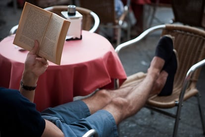 Un hombre leyendo sentado en una terraza de Salamanca.