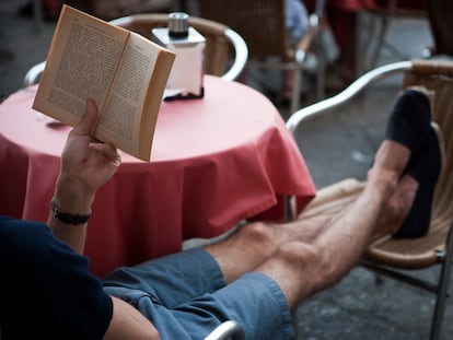 Un hombre leyendo sentado en una terraza de Salamanca.