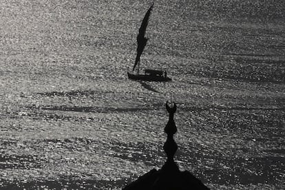 Turistas egipcios viajan por el río Nilo en un barco tradicional, cerca de una mezquita en la ciudad de El Cairo.