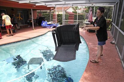 Jackie Kreuter, de 56 años y vecino de Gulfport (Florida), lanza los muebles a la piscina para que no se vuelen durante le huracán, el 5 de septiembre.
