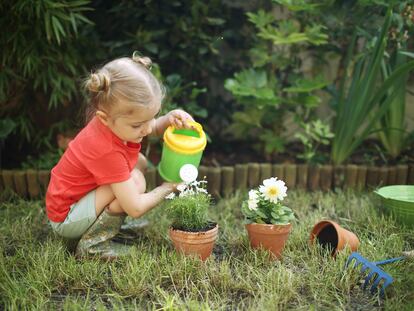 Una niña riega sus plantas.