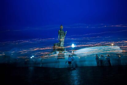 Rayos de luz de las velas marcan los caminos de los seguidores del budismo mientras caminan alrededor de la estatua gigante del Señor Bhudda en el Phutthamonthon en Nakhon Pathom (Tailandia).