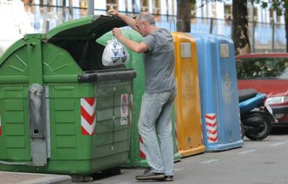 Una persona deposita una bolsa de basura en un contenedor en San Sebastián.