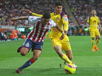 Pineda le gana el balón a Vargas durante el clásico.