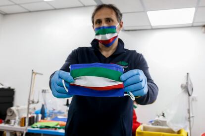 Fabricante mostra máscara de pano feita com as cores da bandeira da Itália, em Roma.