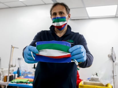 Fabricante mostra máscara de pano feita com as cores da bandeira da Itália, em Roma.