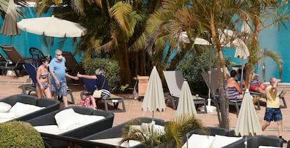 Turistas con máscaras cerca de la piscina del hotel H10 Costa Adeje Palace.