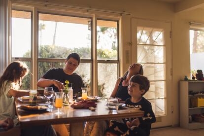 Una familia se sienta junta para comer.