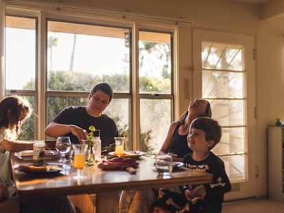 Una familia se sienta junta para comer.