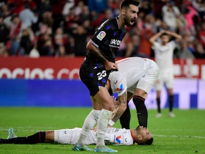 Sevilla's Moroccan forward Youssef En-Nesyri (down) lays on the ground next to Real Sociedad's Spanish midfielder Brais Mendez during the Spanish league football match between Sevilla FC and Real Sociedad at the Ramon Sanchez Pizjuan stadium in Seville on November 9, 2022. (Photo by CRISTINA QUICLER / AFP)