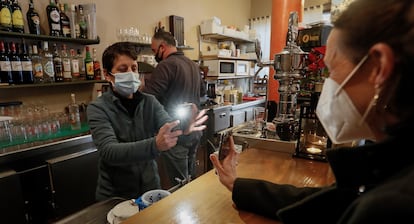 A woman showing her Covid pass at a café in Seville on Monday morning. 