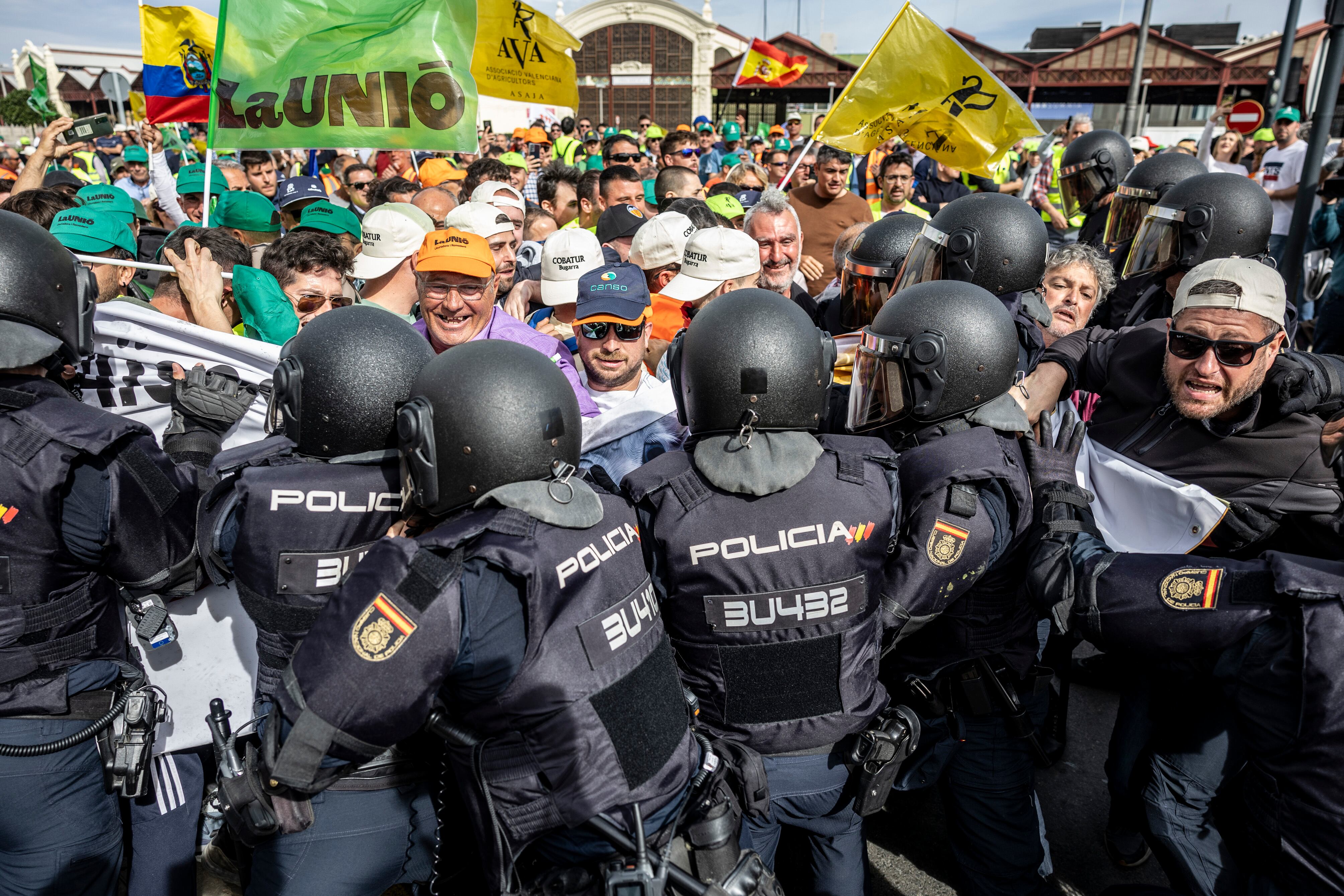 Forcejeo entre agentes de la Policía Nacional y los agricultores, que intentaban protagonizar una sentada ante la sede de la Autoridad Portuaria de Valencia.