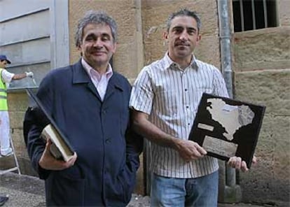 Bernardo Atxaga (izquierda) y Jon Sistiaga posan en San Sebastián con los galardones que recibieron.