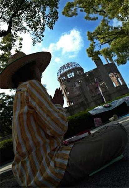 Una mujer reza frente al antiguo Salón Provincial de Exposiciones, declarado Patrimonio de la Humanidad por la Unesco en 1996 como "herencia que transmite a los hombres su pasado histórico".