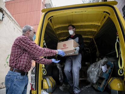 Voluntarios de Càritas descargan una furgoneta de alimentos.