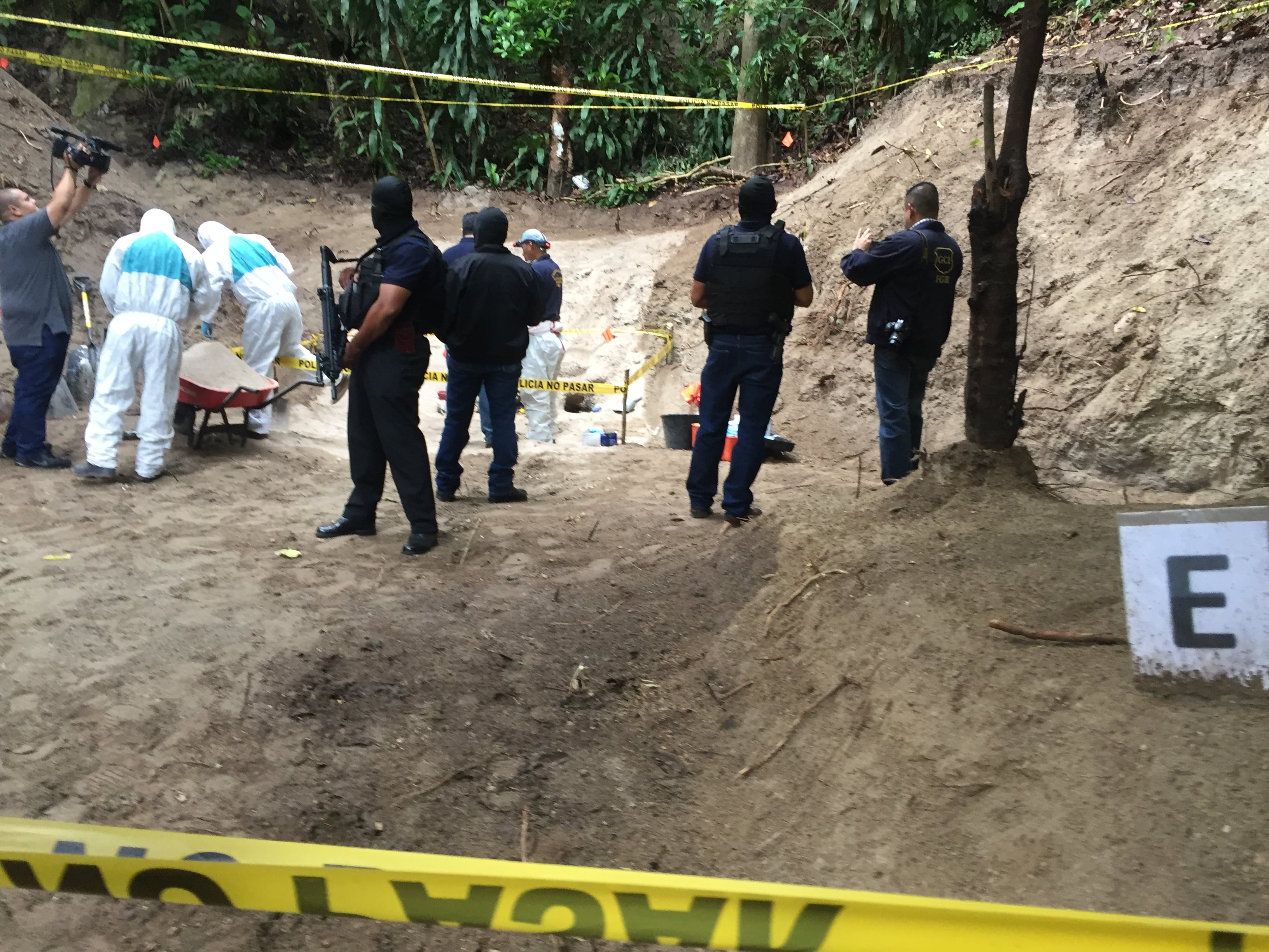 Agentes federales custodian una fosa clandestina en la urbanización Vista al Lago, en El Salvador.