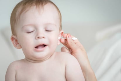 Madre limpia el oído de su pequeño.