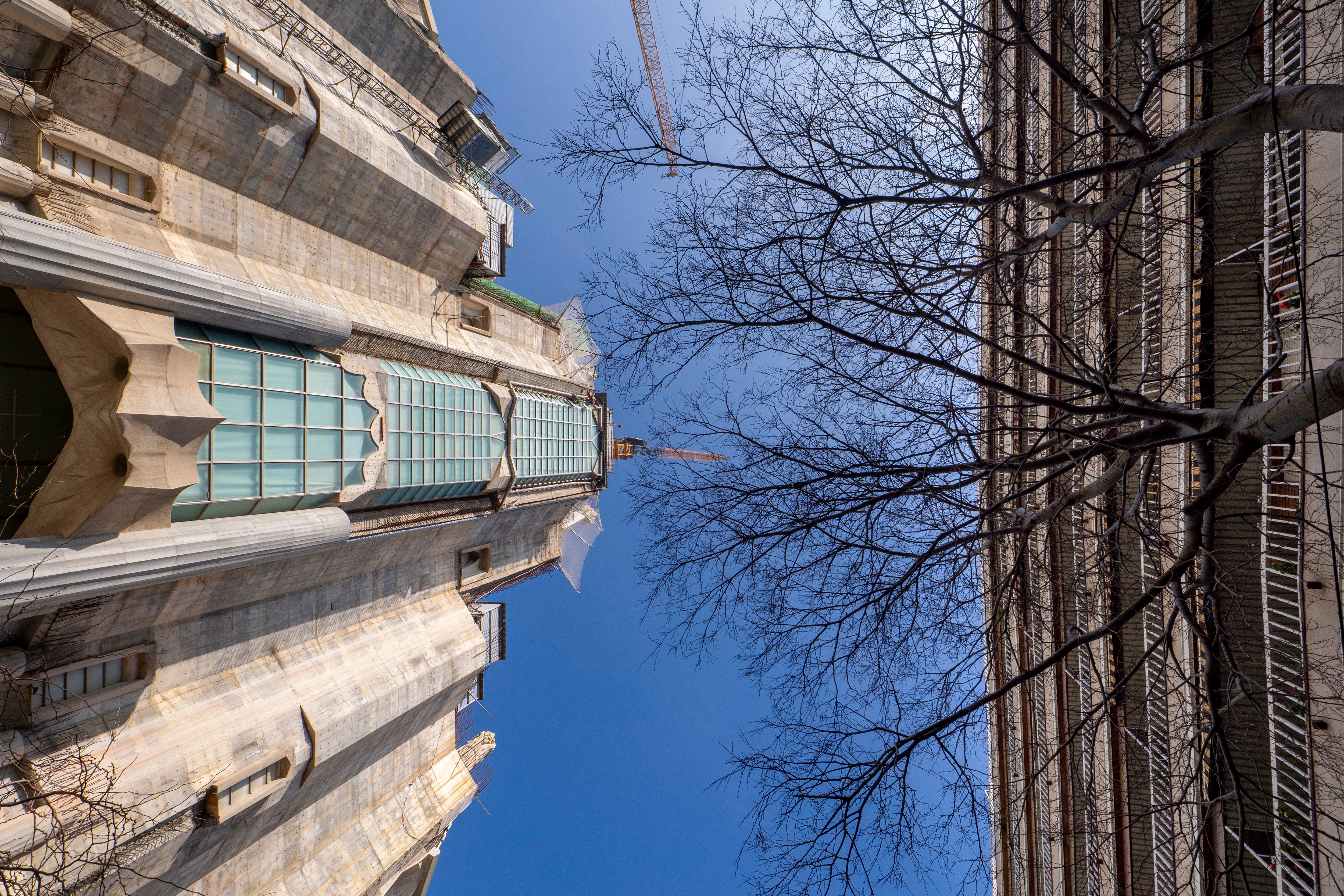 La fachada de la Gloria de la Sagrada Familia, frente a frente con el principal edificio de viviendas amenazado de derribo si se construye la escalinata de acceso al templo.