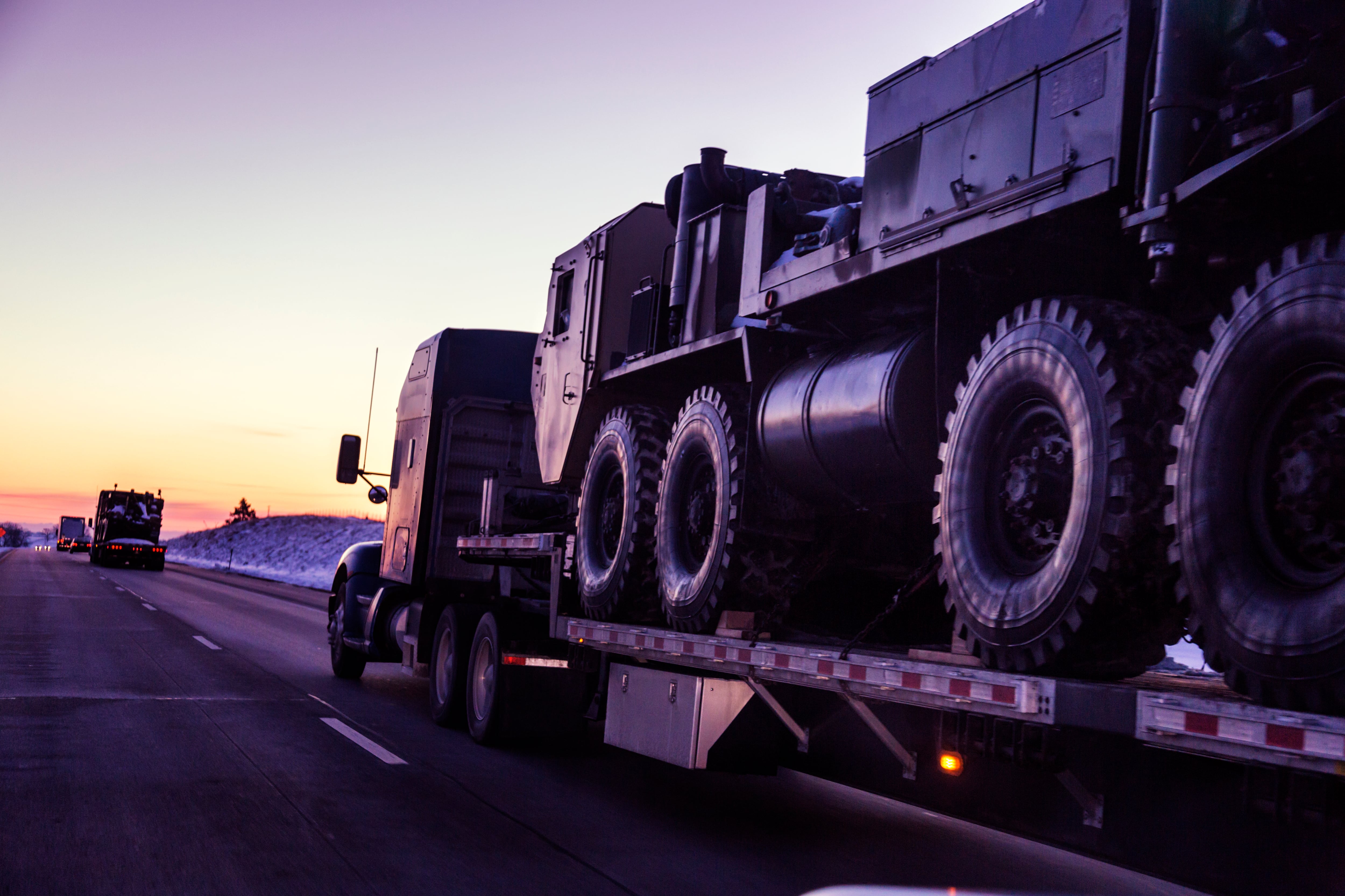 Un convoy de camiones transporta vehículos tácticos blindados del Ejército de Estados Unidos por una autopista en Utah.