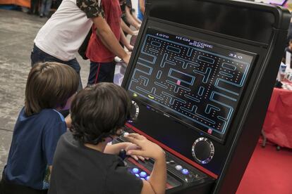 Dos niños juegan a Pac-Man en Retrobarcelona.