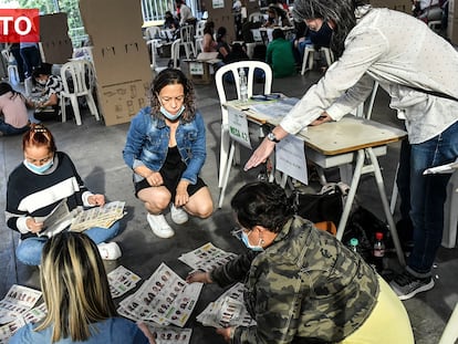 People count ballots at a polling station after votation closed in Medellin, Colombia during the presidential election, on May 29, 2022. - Colombians started voting Sunday in a first round of presidential elections, with a leftist poised for victory for the first time in the country's troubled history. (Photo by JOAQUIN SARMIENTO / AFP)