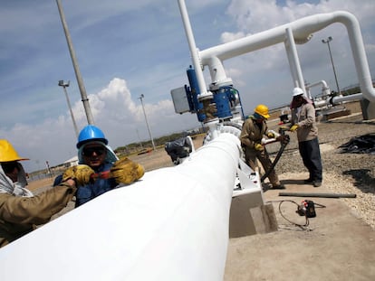 Trabajadores en Manaure (Colombia) ajustan una válvula del gasoducto que conecta con Venezuela, en 2007, un día antes de su inauguración.