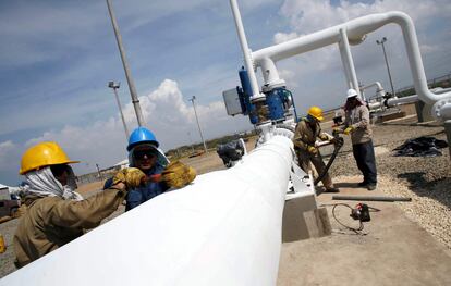 Trabajadores en Manaure (Colombia) ajustan una válvula del gasoducto que conecta con Venezuela, en 2007, un día antes de su inauguración.