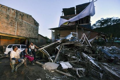 Una familia junto a los escombros de su casa destruida tras la avalancha en la ciudad colombiana de Mocoa, el 1 de abril de 2017.