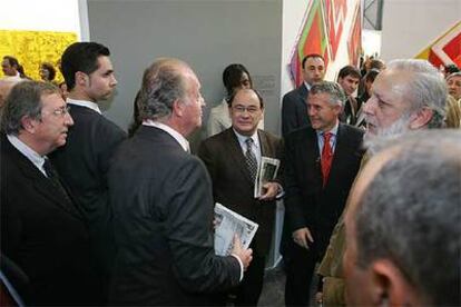 El Rey, durante su visita al pabellón de EL PAÍS, conversa con Jesús Ceberio (segundo por la derecha), director del diario, en presencia del artista Juan Navarro Baldeweg, que aparece a la izquierda de la imagen.