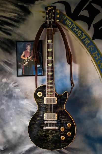 El modelo Gibson Les Paul con el que grabó Juan Valdivia 'Avalancha', colgado en el salón de su casa. Al lado, una foto de un concierto en Suiza, el primero donde sufrió el dolor de mano. 
