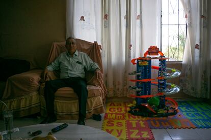 Armando Reyes en su salón, rodeado por los juguetes de su hijo Edwin, de siete años. 