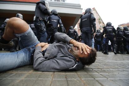 Un hombre cae al suelo durante la carga de los antidisturbios (UIP) de la Policía Nacional en la Escola Mediterránea de la Barceloneta en Barcelona. Incidentes entre votantes y Guardia Civil y Policía Nacional en el día del referéndum ilegal independentista catalán del 1-O. Desafío independentista en Cataluña. 