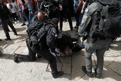 La Media Luna Roja palestina informó de que ha atendido a decenas de heridos en el entorno del hospital. En la imagen, agentes de policía israelí detienen a un hombre durante el funeral. 