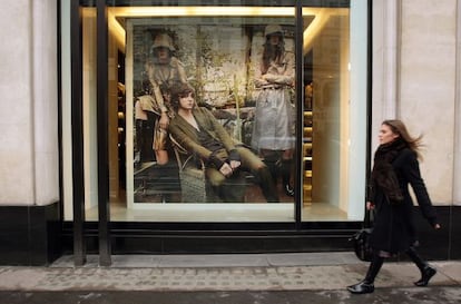 Una mujer pasea frente a un anuncio de ropa por una calle de Londres