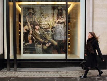 Una mujer pasea frente a un anuncio de ropa por una calle de Londres