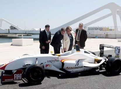 El presidente de la Generalitat, la alcaldesa de Valencia, el presidente de Valmor Sports, Fernando Roig, y el directivo de esta empresa Jorge Martínez Aspar contemplan un monoplaza durante su visita a las obras del circuito.