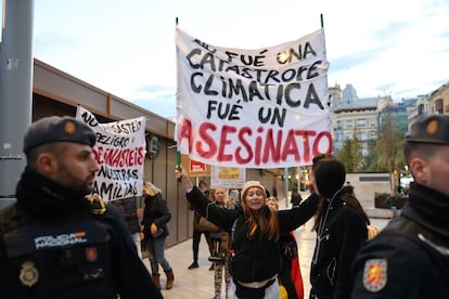 Una mujer porta una pancarta de protesta en los aledaños de la catedral de Valencia.