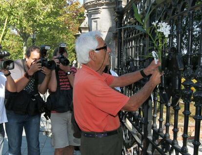 Un vecino coloca unas flores en la verja de la casa del Promontorio, residencia habitual en Santander de la familia Botín