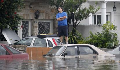 Un hombre encima de un coche en una calle de Buenos Aires (Argentina). Los barrios más afectados son los de Palermo, Belgrano, Núñez y Villa Urquiza.