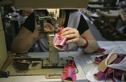 Una mujer cose unas sandalias en una fábrica de calzados en Monóvar (Alicante).