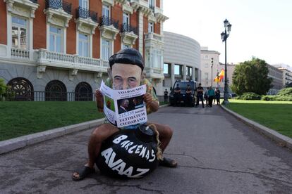 Un cabezudo que representa a Mariano Rajoy lee un periódico sentado sobre una bomba con el 'caso Bárcenas' en las inmediaciones del Senado.