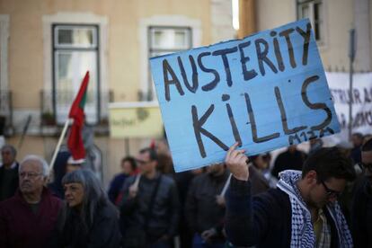 Un manifestante sostiene un cartel en que se lee "La austeridad mata", en una protesta frente al Parlamento portugués en Lisboa.