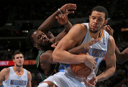 JaVale McGee, de los Denver Nuggets, lucha por un rebote con DeMarre Carroll, de los Utah Jazz